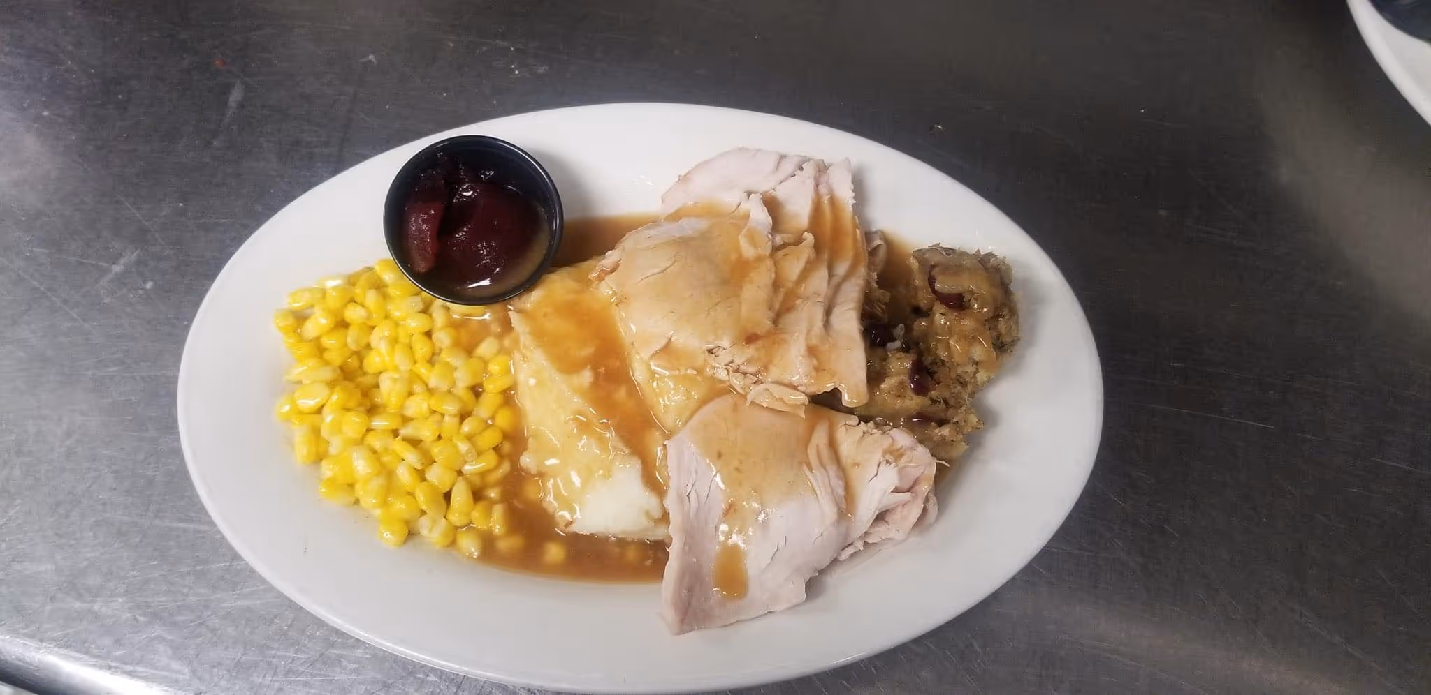 A plate of food with turkey and gravy.