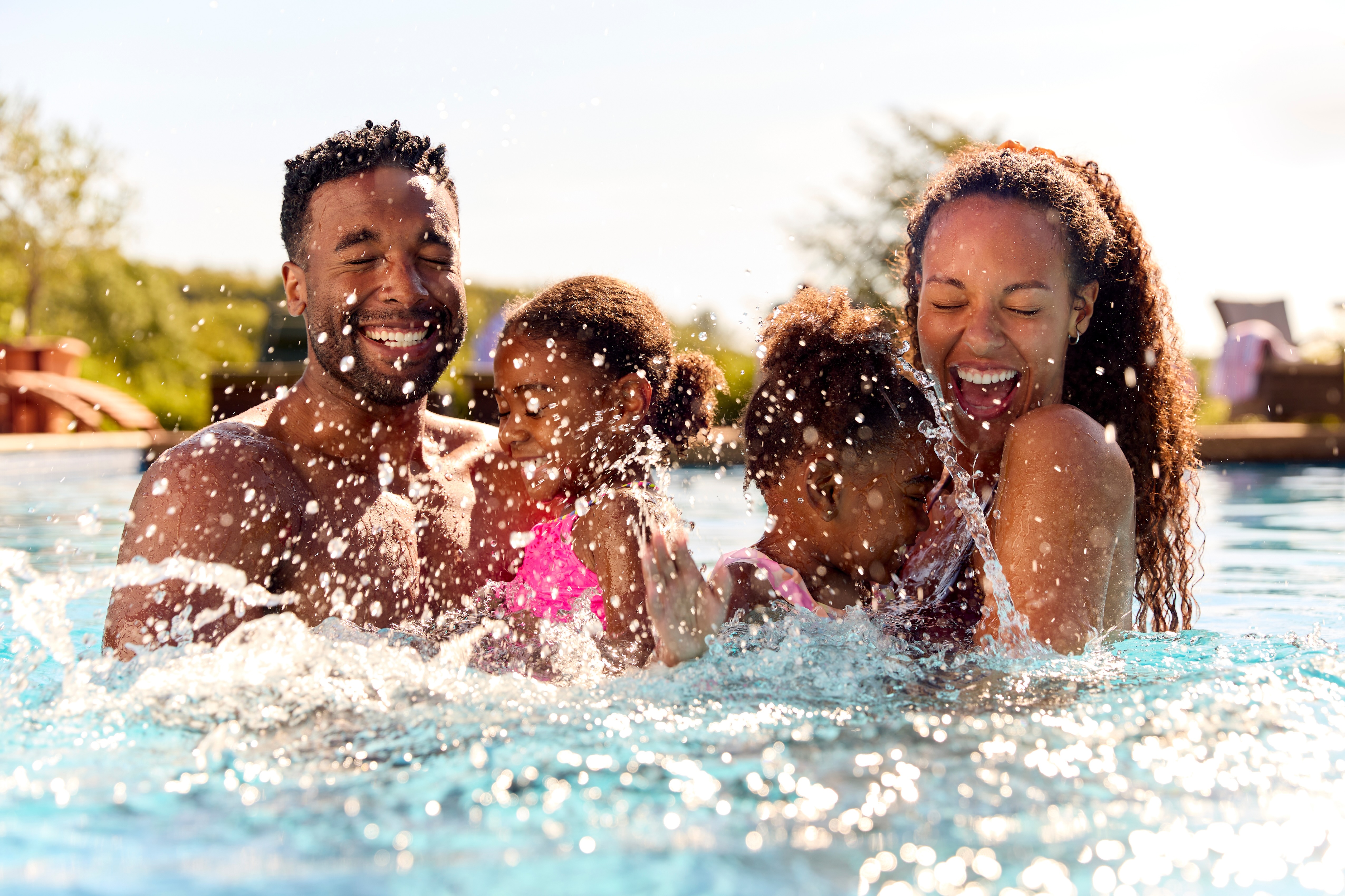 Family playing in the pool stock photo