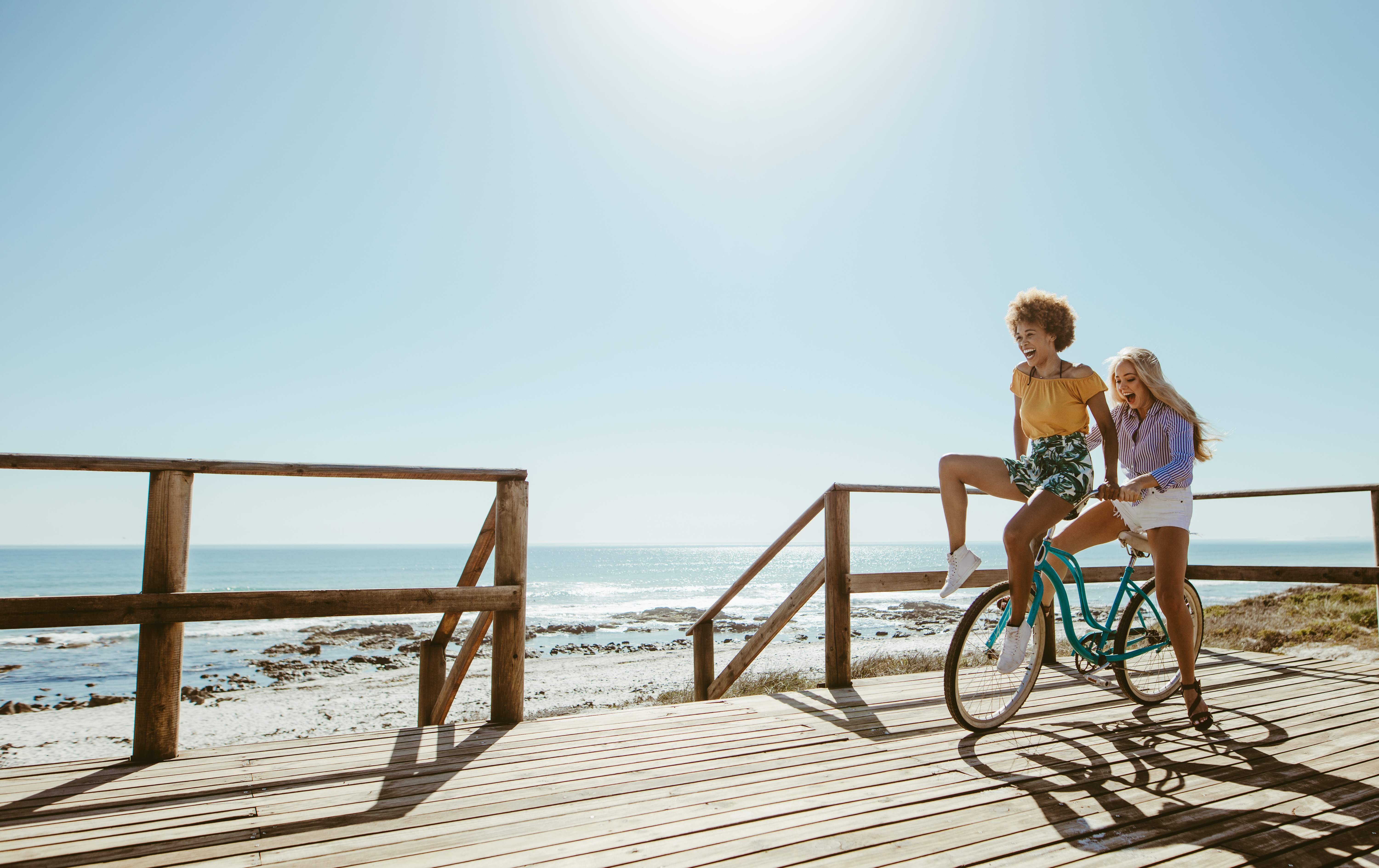Friends on a bike at the beach stock photo