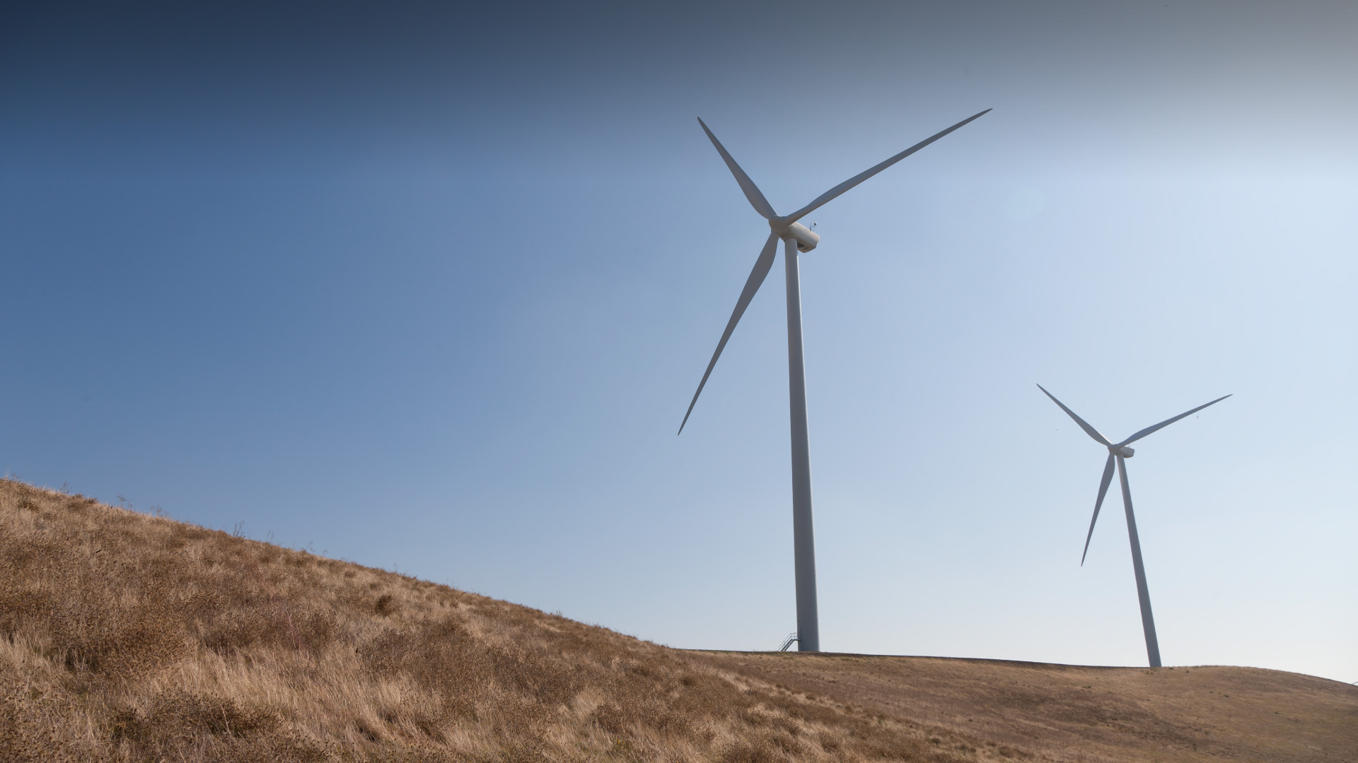 Crane putting turbine blades onto a wind turbine base