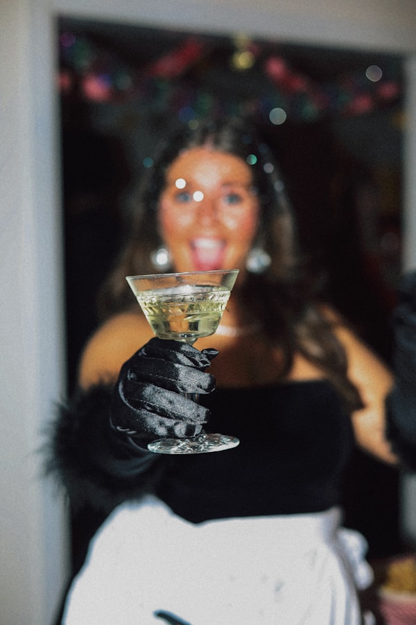 Woman with champagne glass at a vintage Christmas party. Disco ball earrings and fuzzy gloves