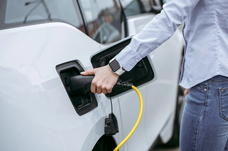 A person plugging in their electric car.