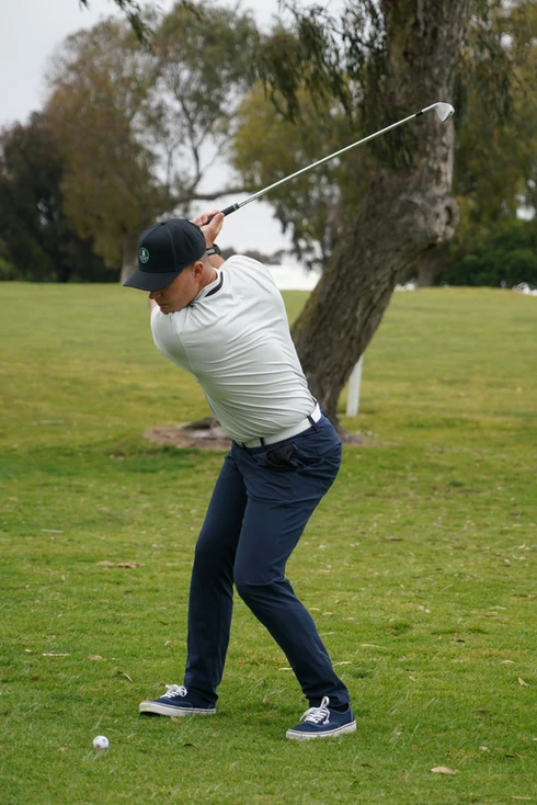 Man swinging golf club with appropriate ranges of motion