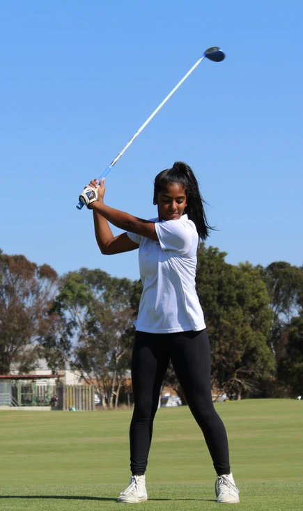 Young woman swinging golf club without appropriate motion.