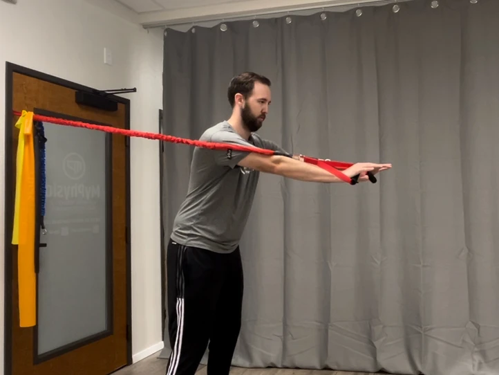 Man using elastic tubing for chest press exercise