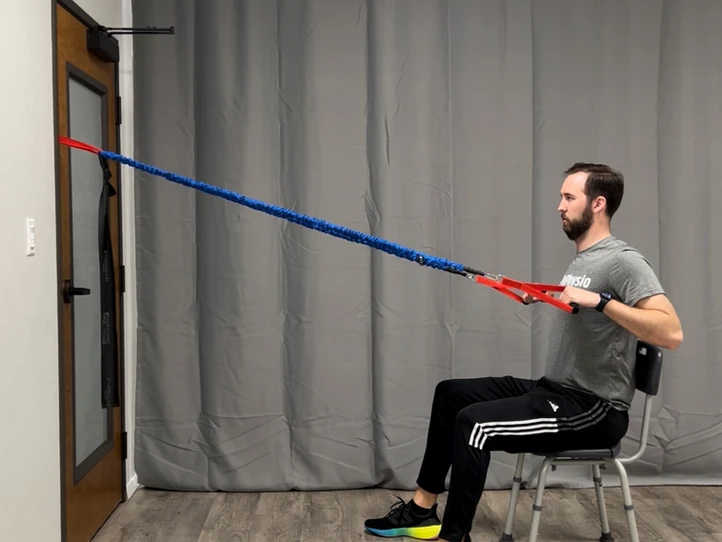 Man using elastic tubing for seated row exercise