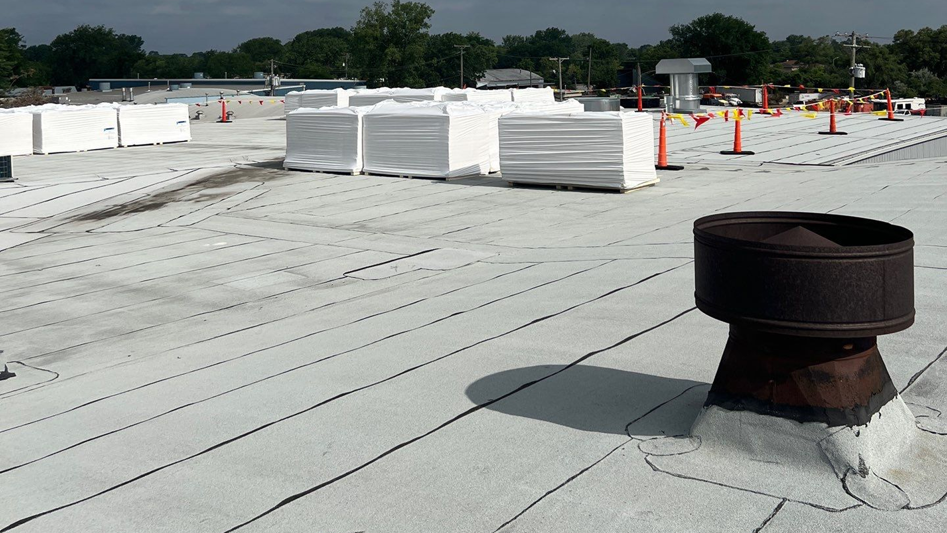Close-up of roof with lifted and missing shingles exposing the underlayment beneath