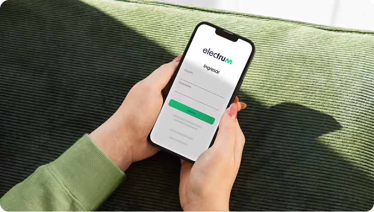 Person holding phone showing Electrum app login screen with fields for email and password.