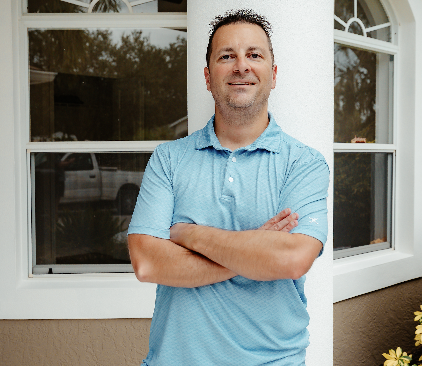 Author Greg Junge posing in front of a house for a photo