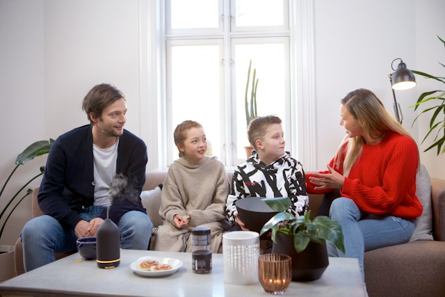 Parents talking to their children on a couch in a decorated room