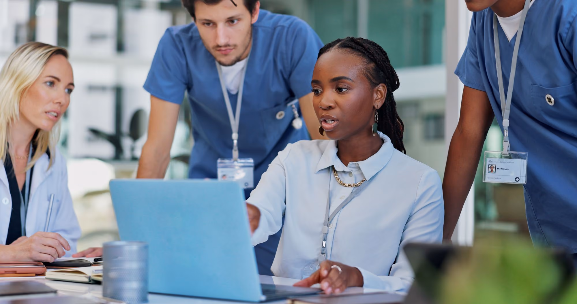 Two health care providers looking at a laptop together.