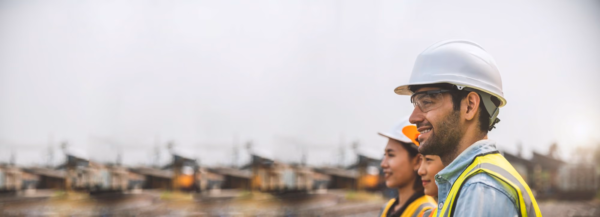 Construction workers in hard hats and safety vests standing outdoors