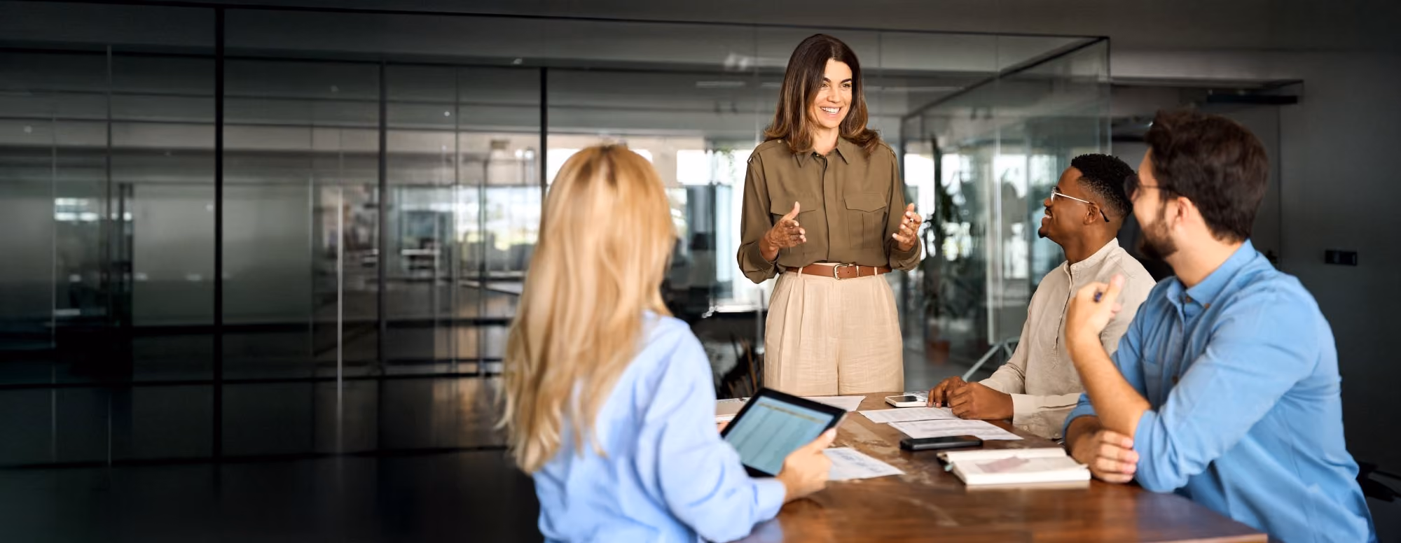 Woman speaking to a group of colleagues in an office.