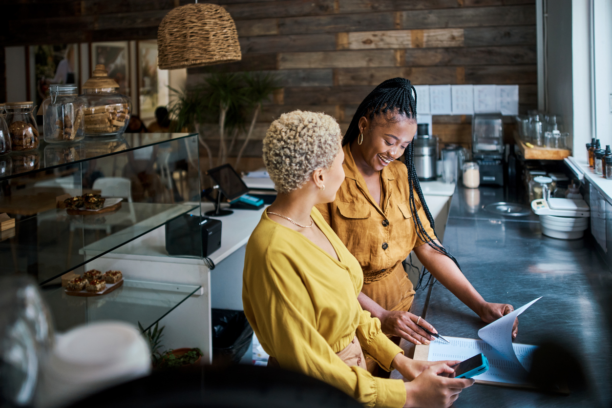 Two small business owners review paperwork. 