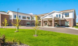Exterior view of Cascade Creek memory care facility in Rochester, MN, featuring modern architecture, landscaped lawn, and welcoming entrance.