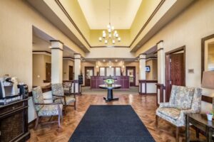 Front lobby of Anthem Memory Care in Burr Ridge, IL, featuring decorative chairs, a central table with flowers, and a welcoming atmosphere.