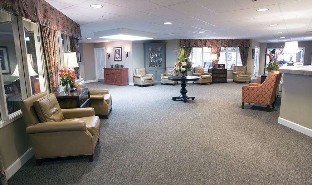 Lobby of Anthem Memory Care community featuring elegant decor, seating area with patterned chairs, reception desk, and welcoming atmosphere.