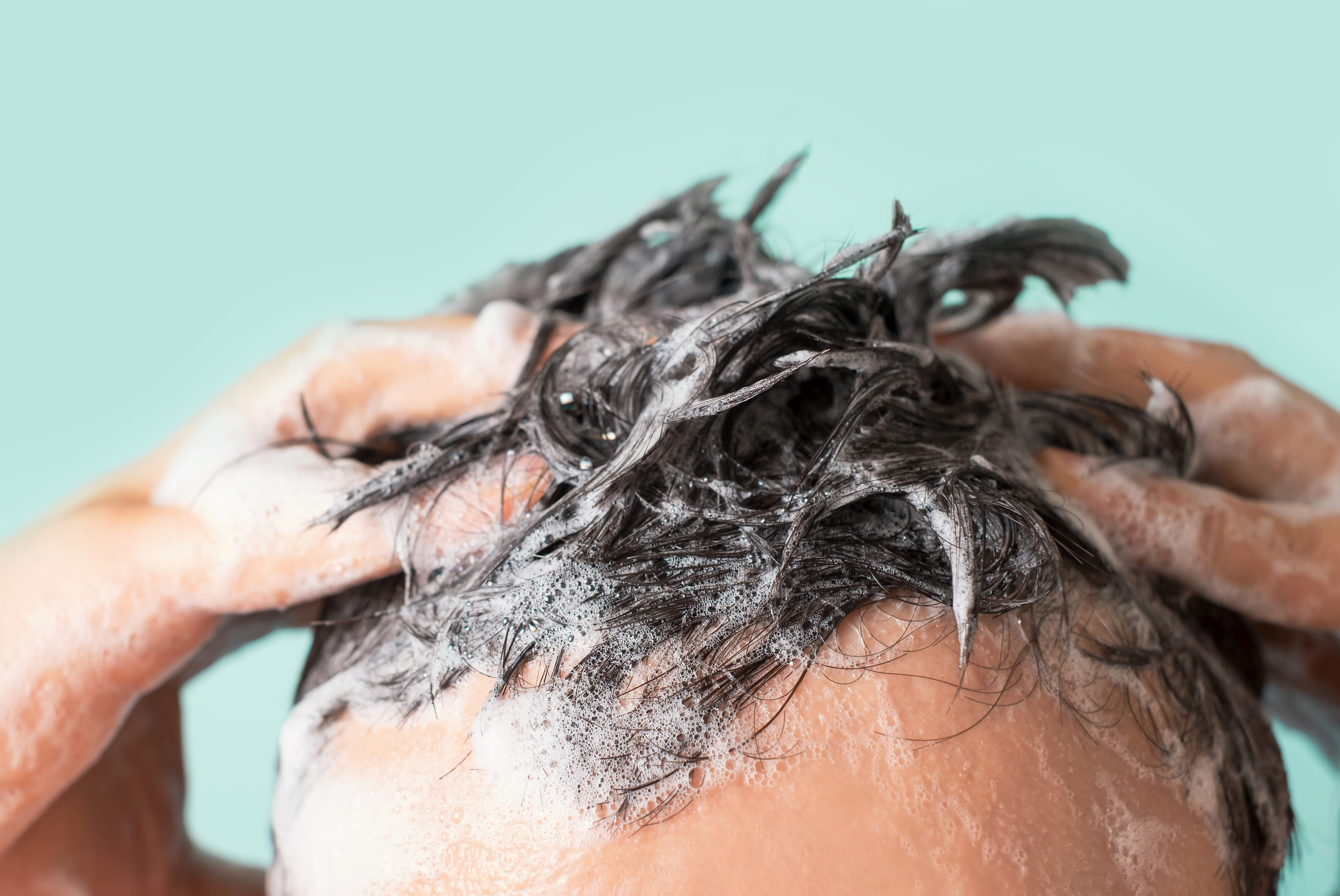 Un uomo si fa lo shampoo dopo il trapianto di capelli