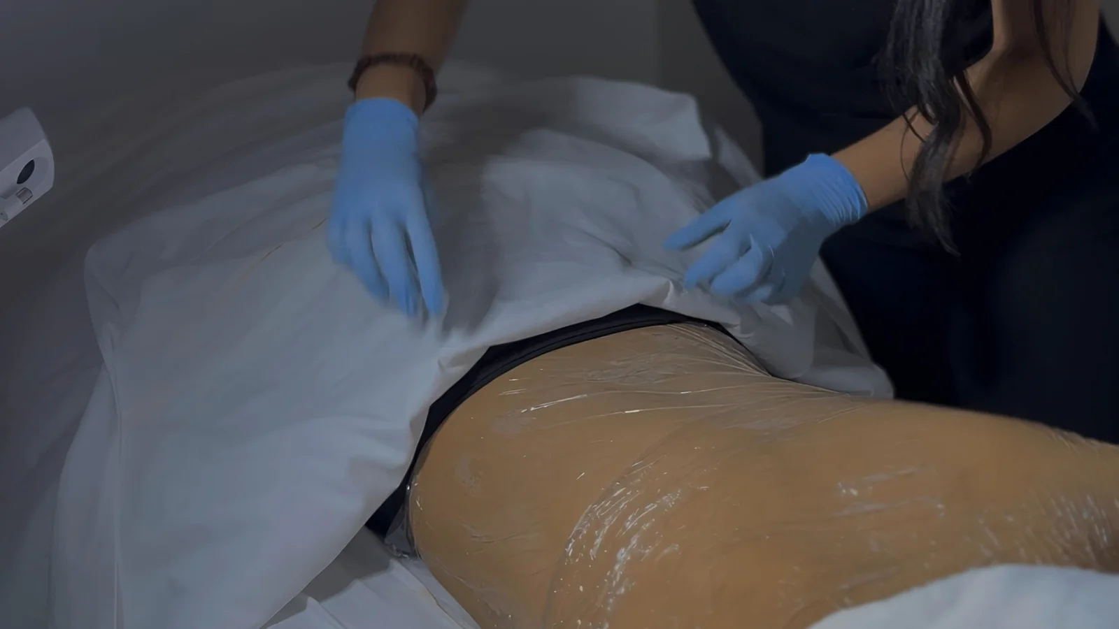Thermal wrap applied over the lower back to help a clarifying mask absorb during a back facial