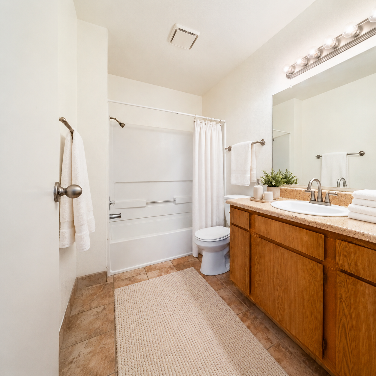 Bathroom with shower tub combo and vanity with brown cabinets