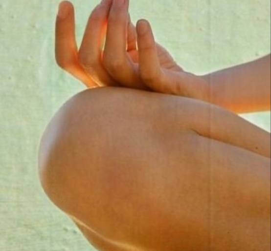 Person sitting cross-legged in a calm meditation pose with eyes closed
