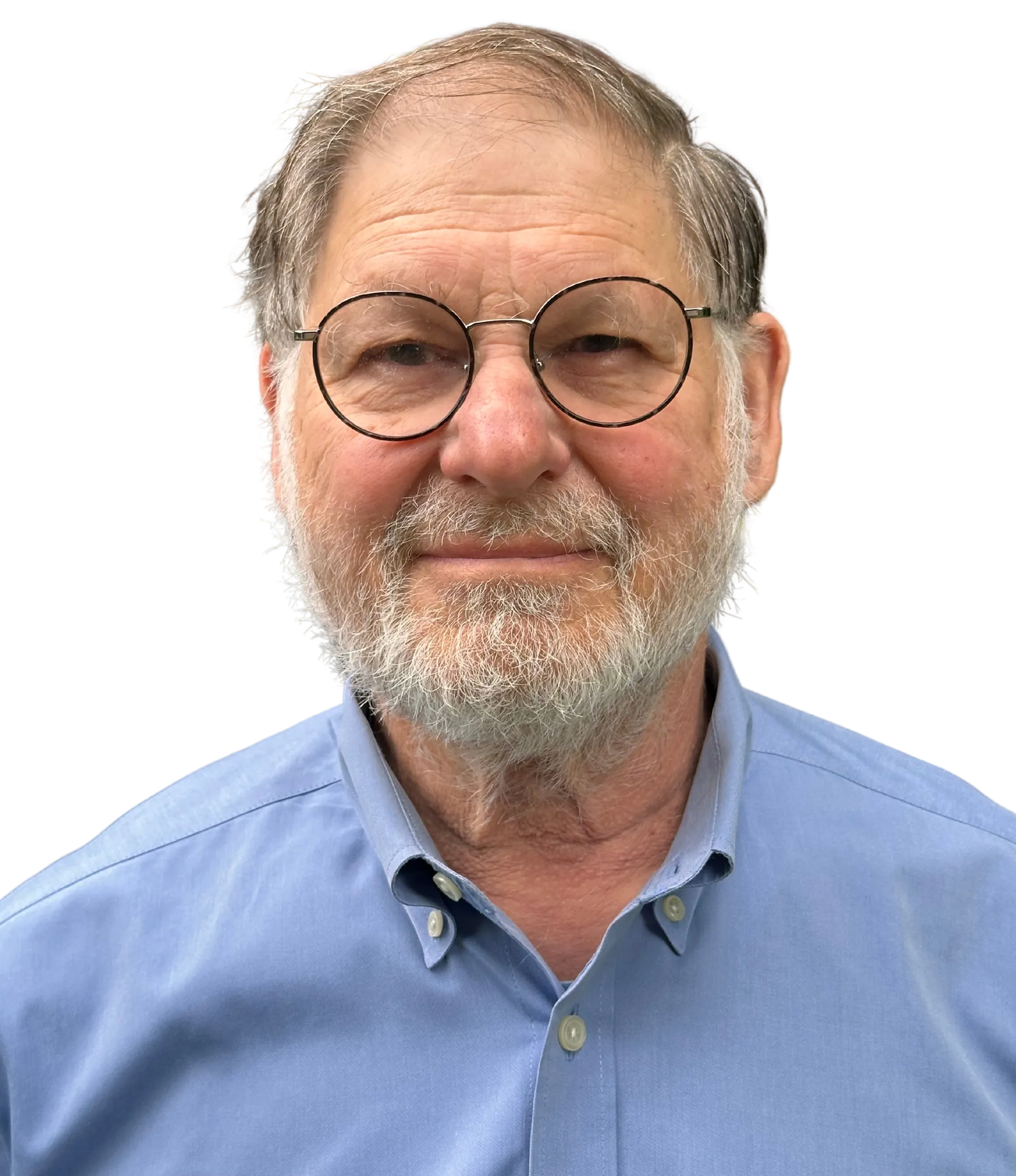 Older man with gray beard and round glasses wearing a light blue buttoned shirt, smiling gently.