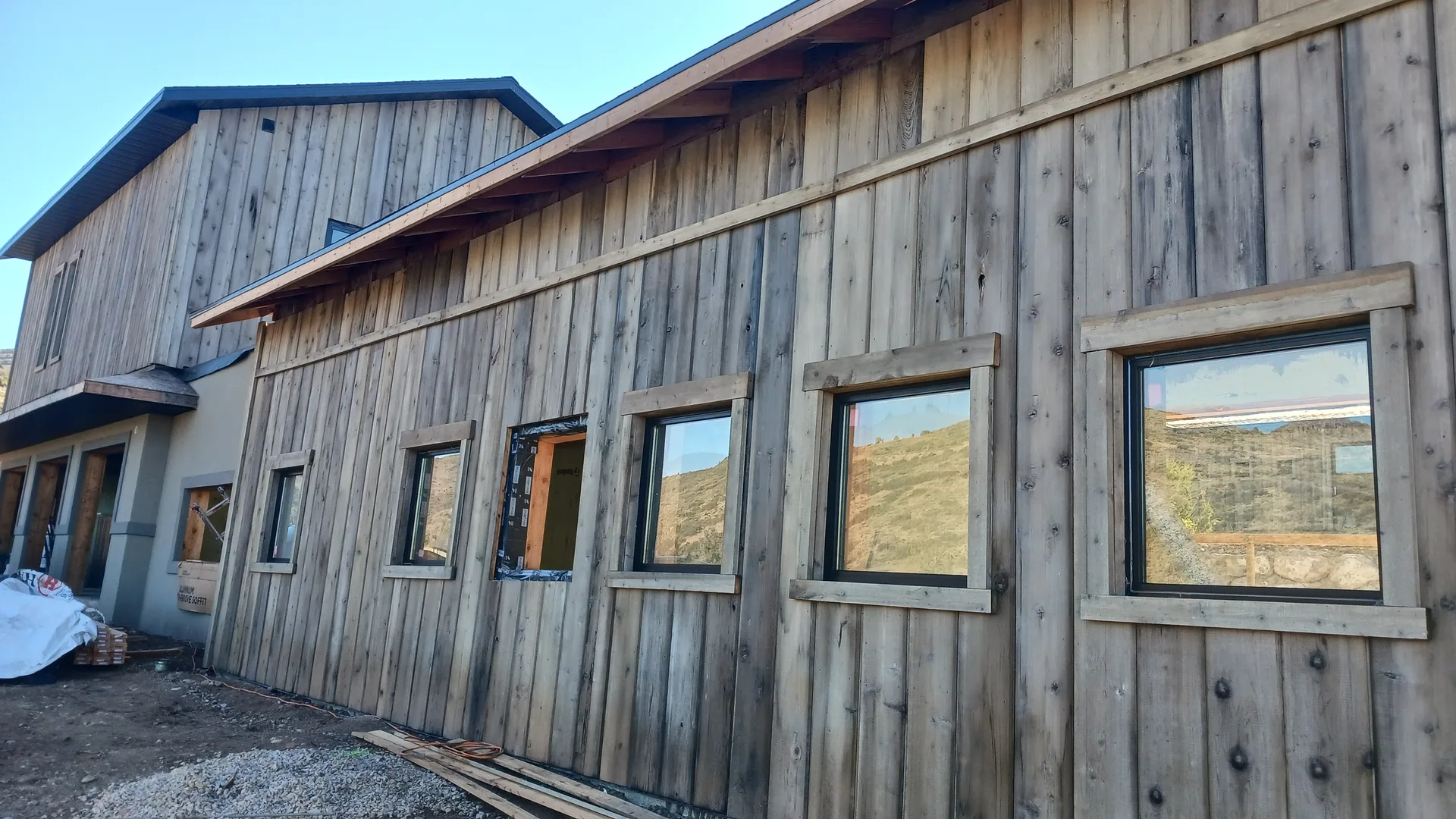Wood-paneled building with several square windows.