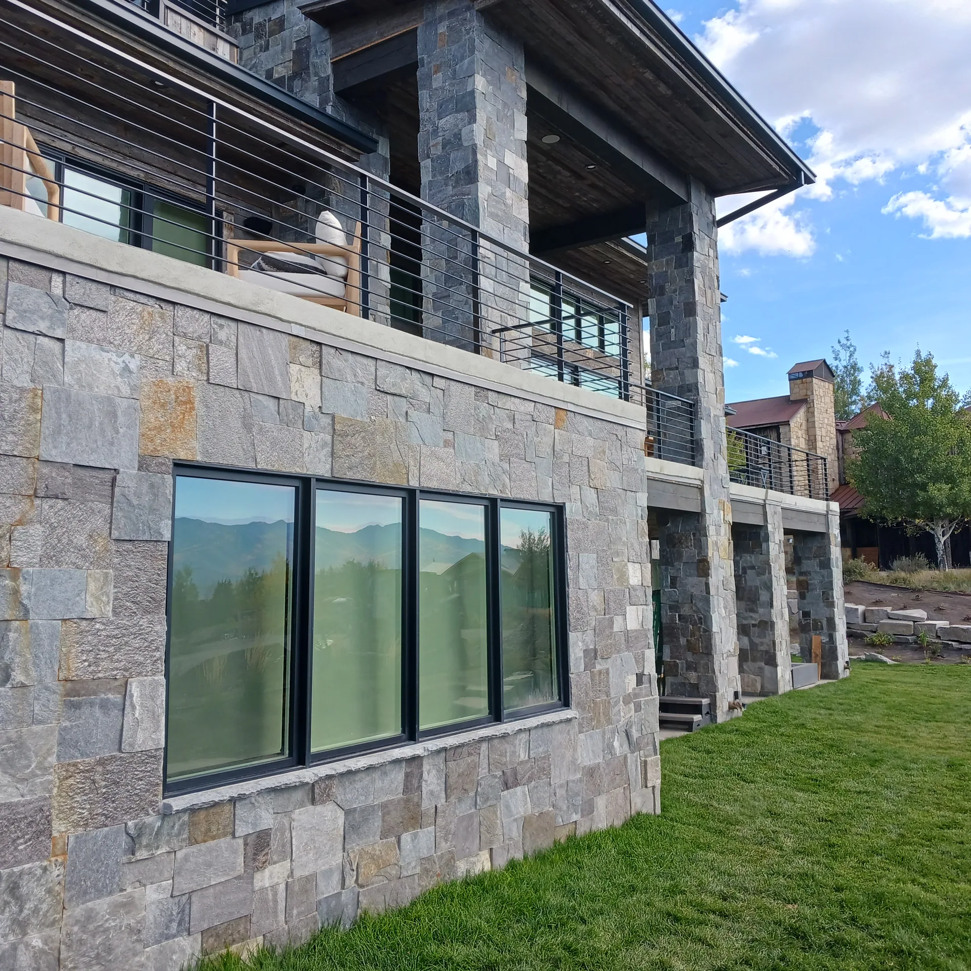 Modern house with stone exterior and columns.