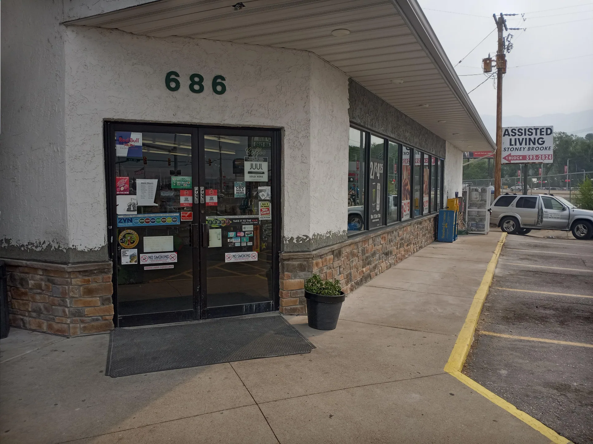 Storefront with stone base and repaired trim below windows.