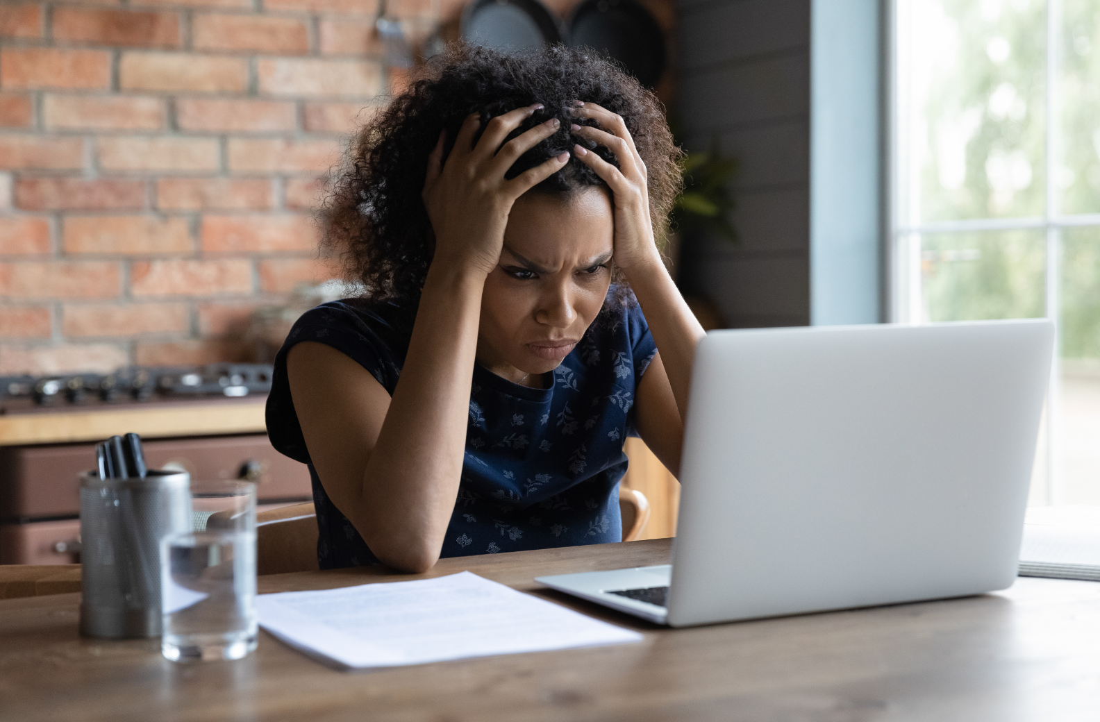 business owner looking frustratedly at her laptop screen