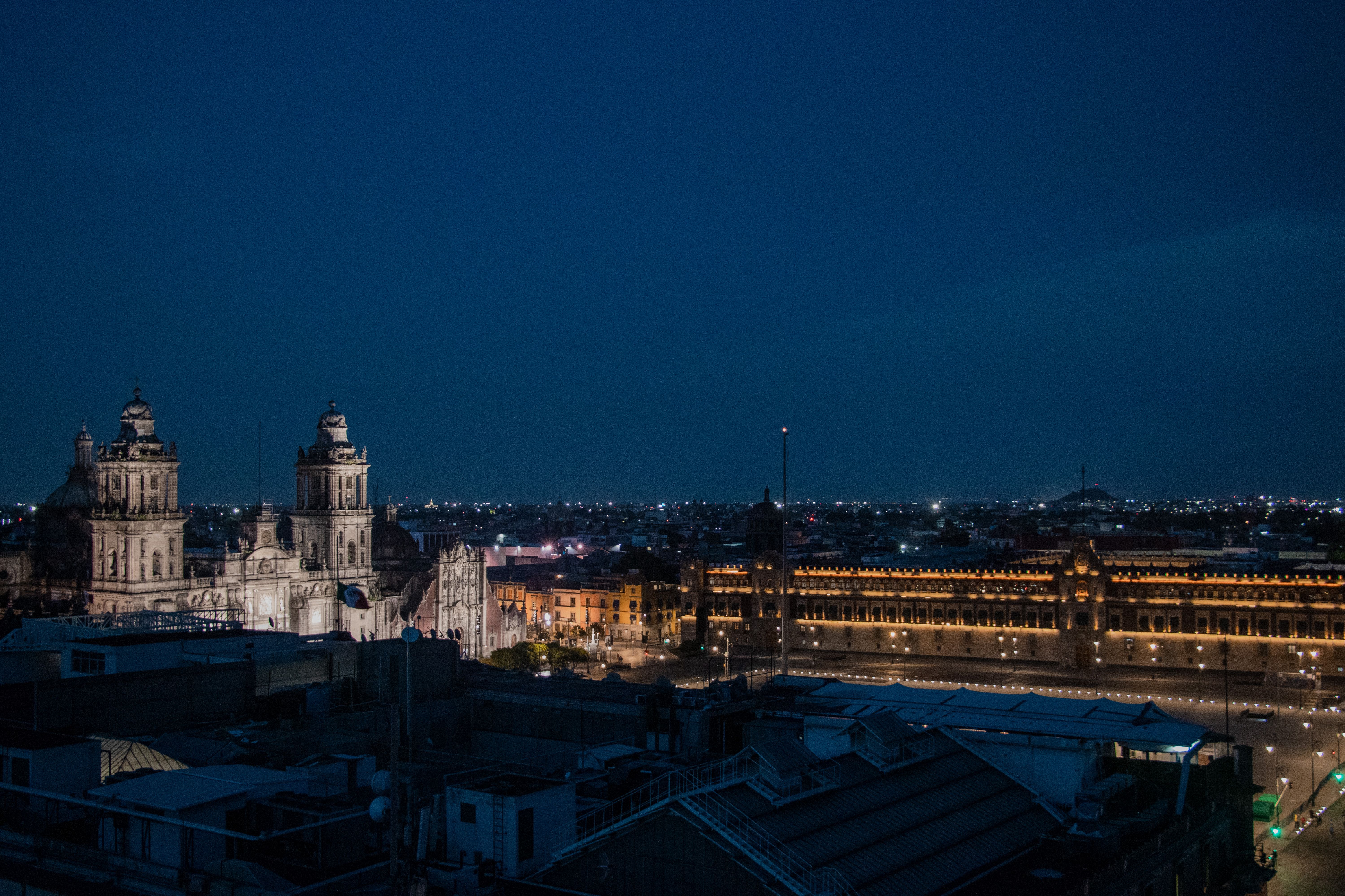 The Metropolitan Cathedral and Palacio Nacional glow over the Zocalo at night in Mexico City's Centro Historico. Photo by FranDany on Pexels.