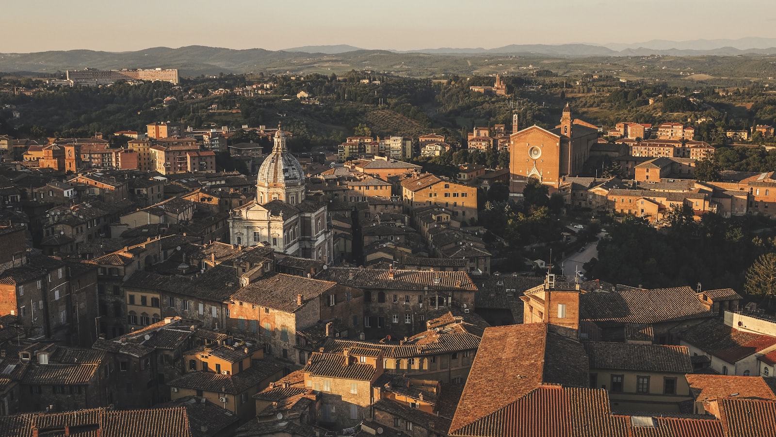 Late light over Siena's rooftops, domes, and bell towers. Photo by Cristina Gottardi on Unsplash.