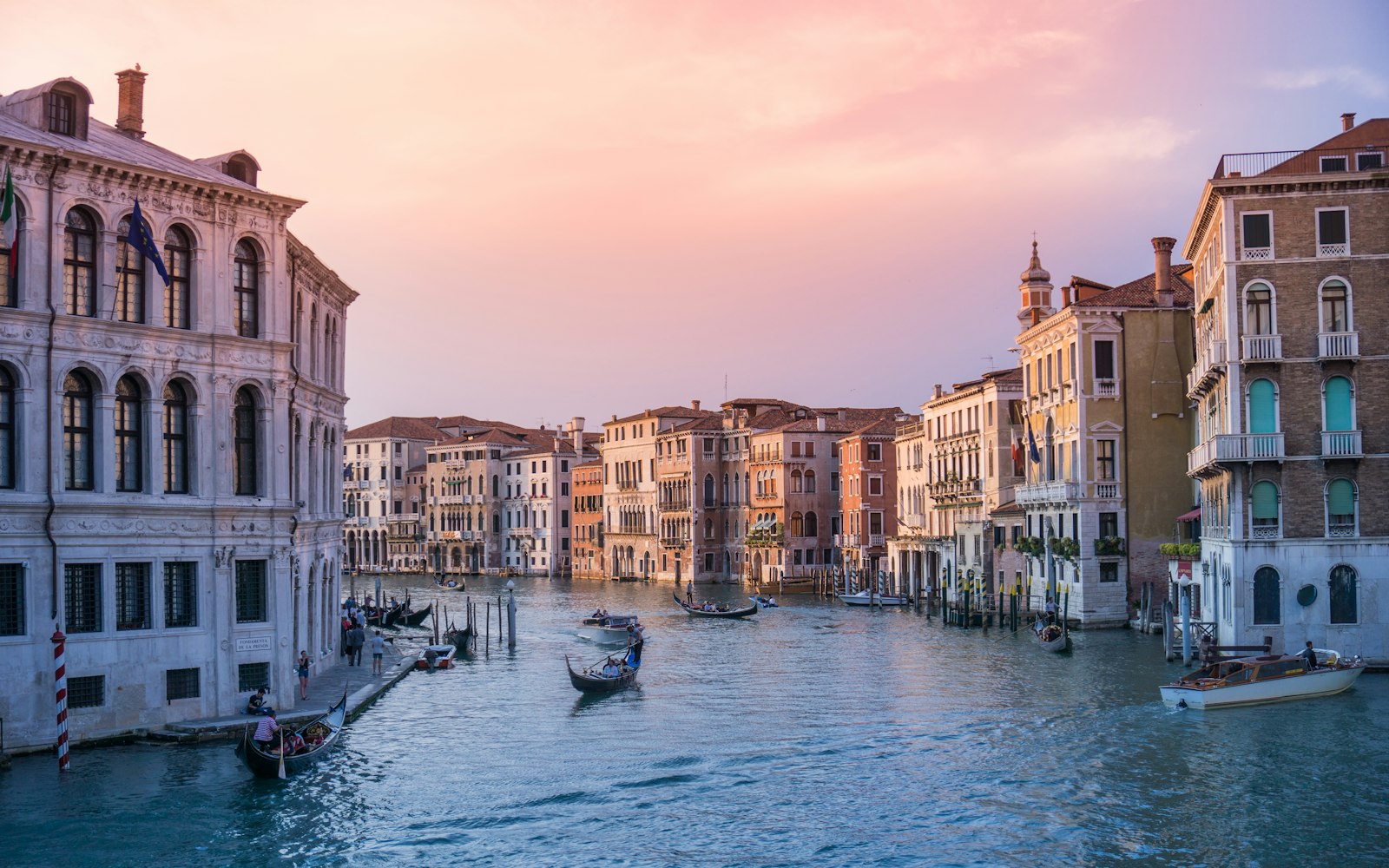 Gondolas moored on the Riva at dusk, San Giorgio Maggiore across the basin. Photo by Rebe Adelaida on Unsplash.