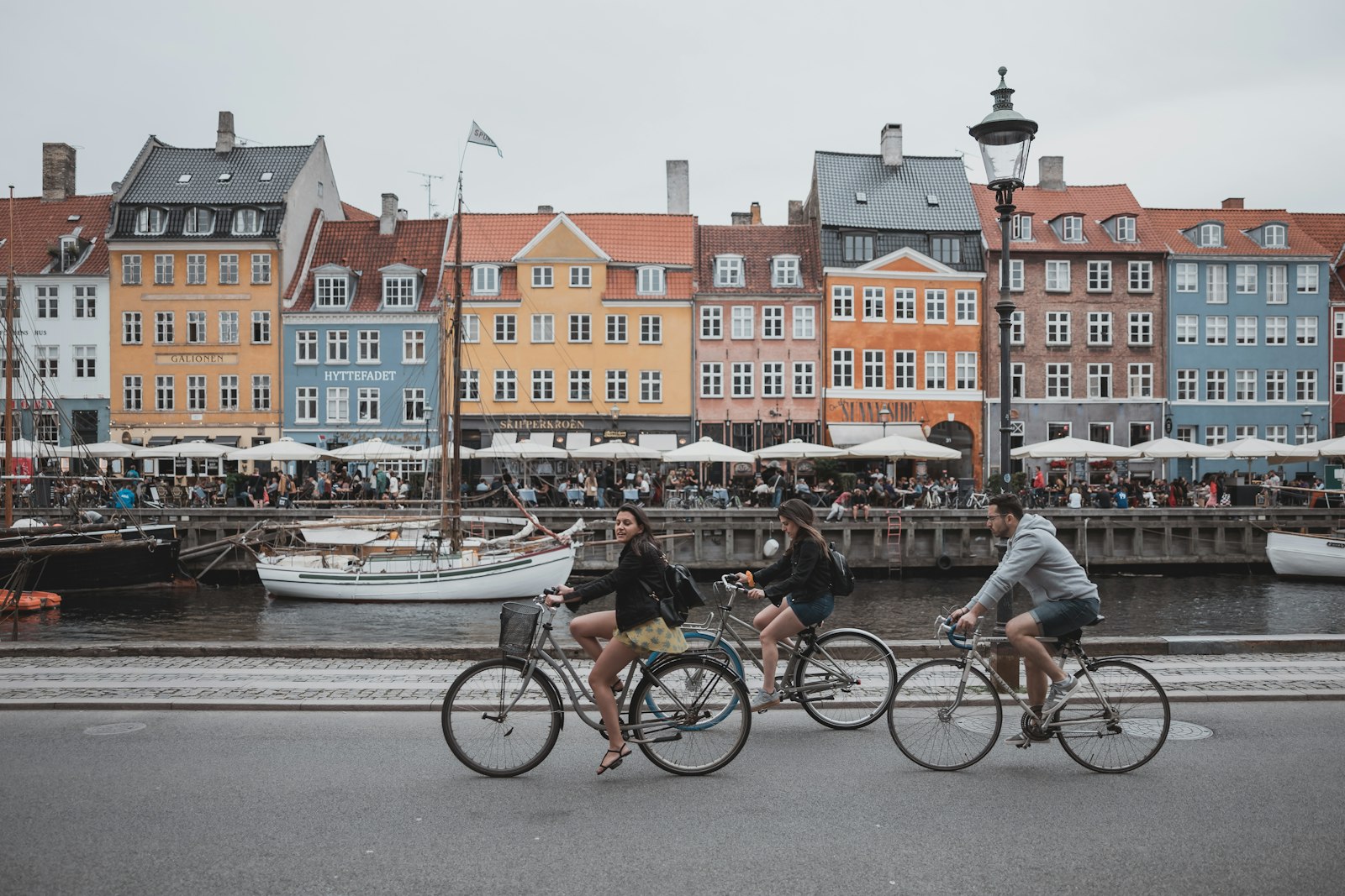 Cyclists riding past Nyhavn's harbor front. Photo by Febiyan on Unsplash.