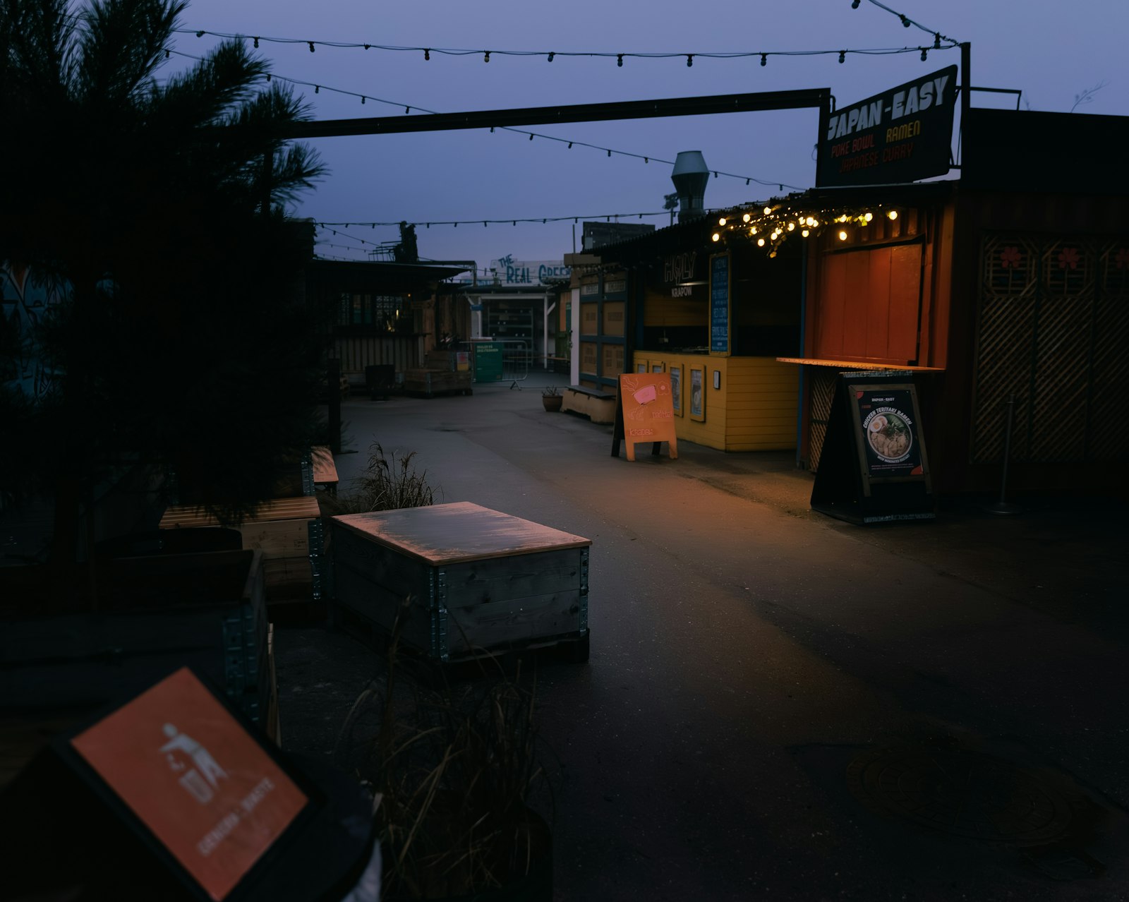 Street-food stalls under string lights at Reffen at dusk. Photo by heino eisner on Unsplash.