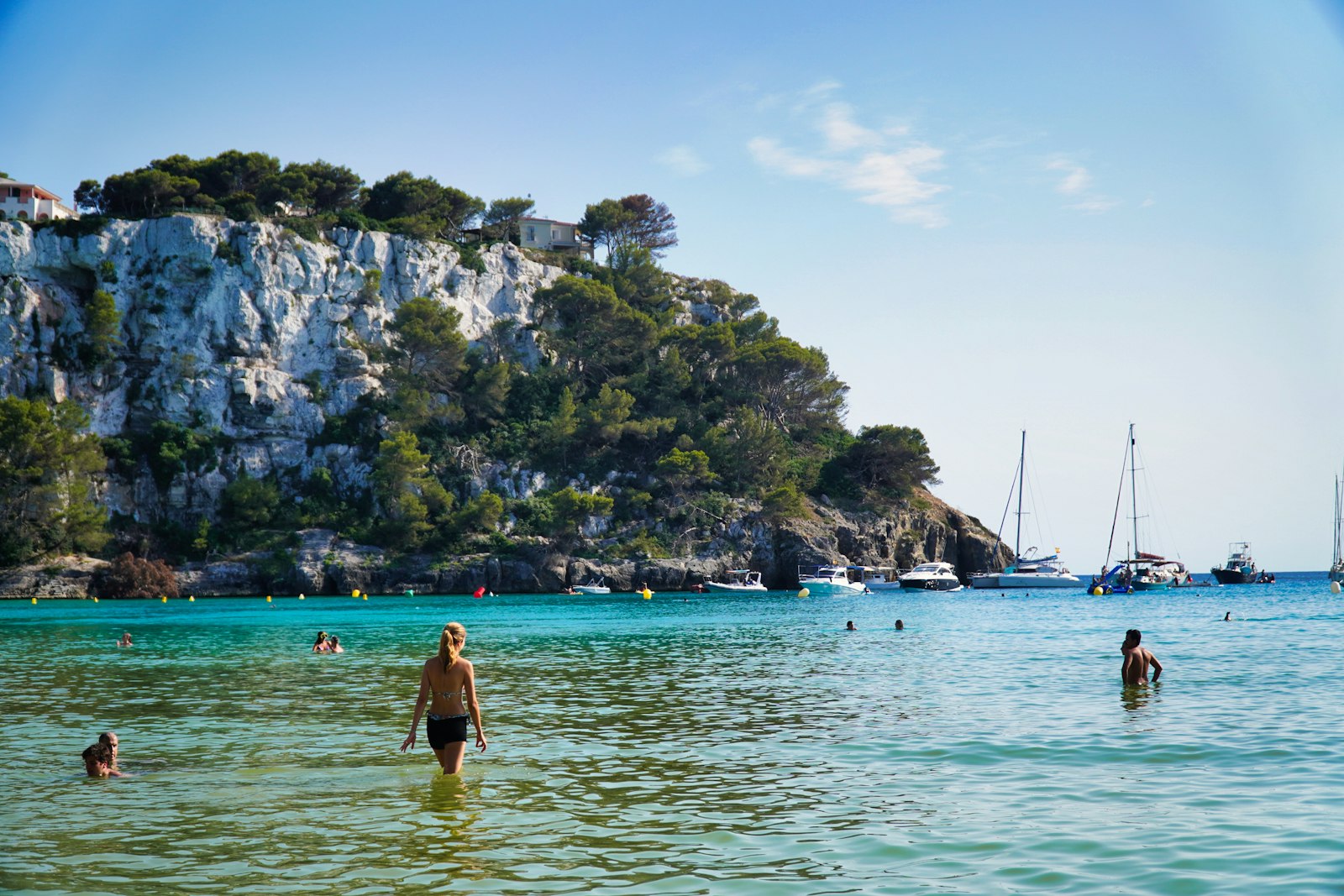A sailboat anchored in the turquoise of a Menorcan cove. Photo by Márcio Azevedo on Unsplash.