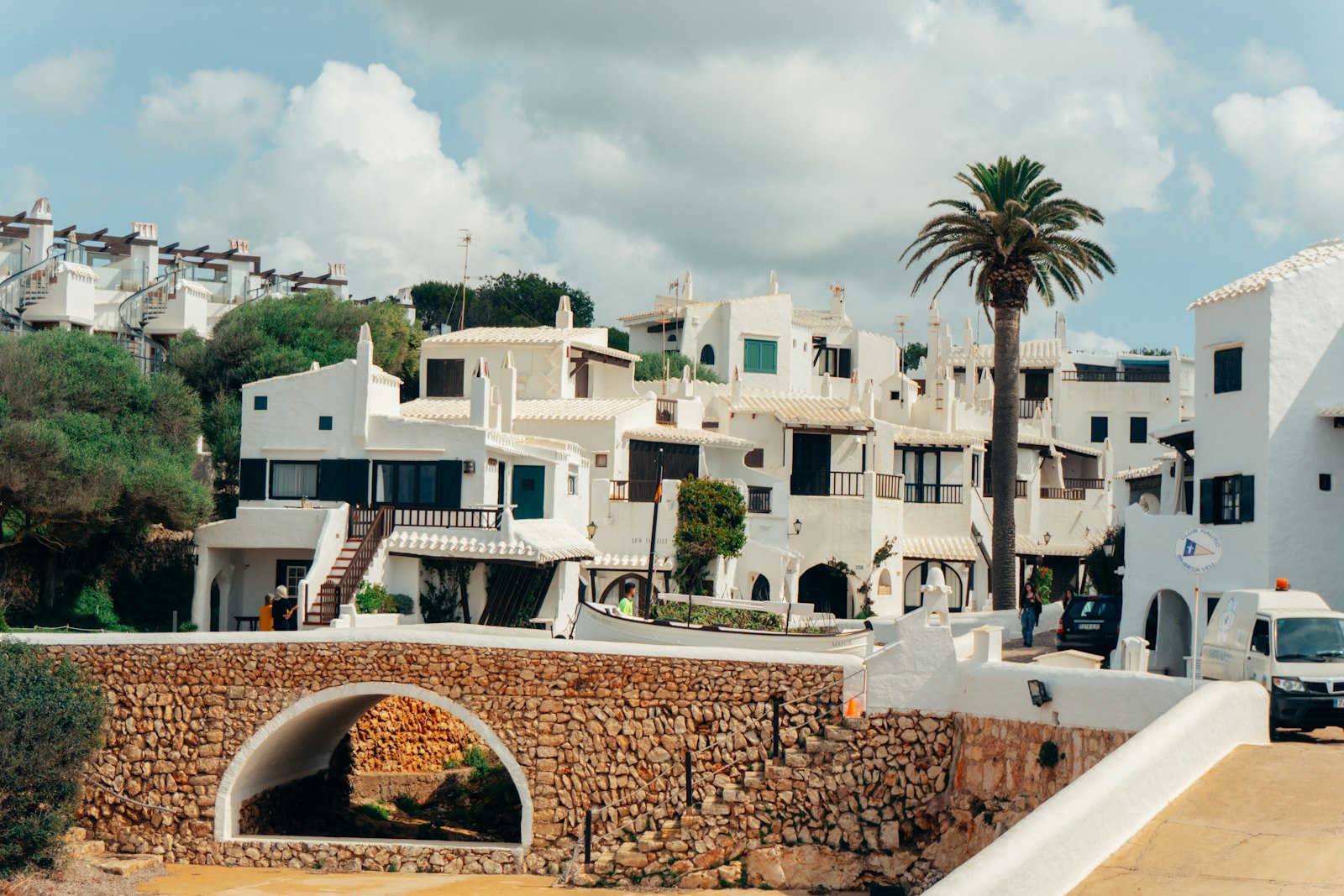 Whitewashed lanes and a stone arch in a Menorcan coastal village. Photo by Raymond Petrik on Unsplash.