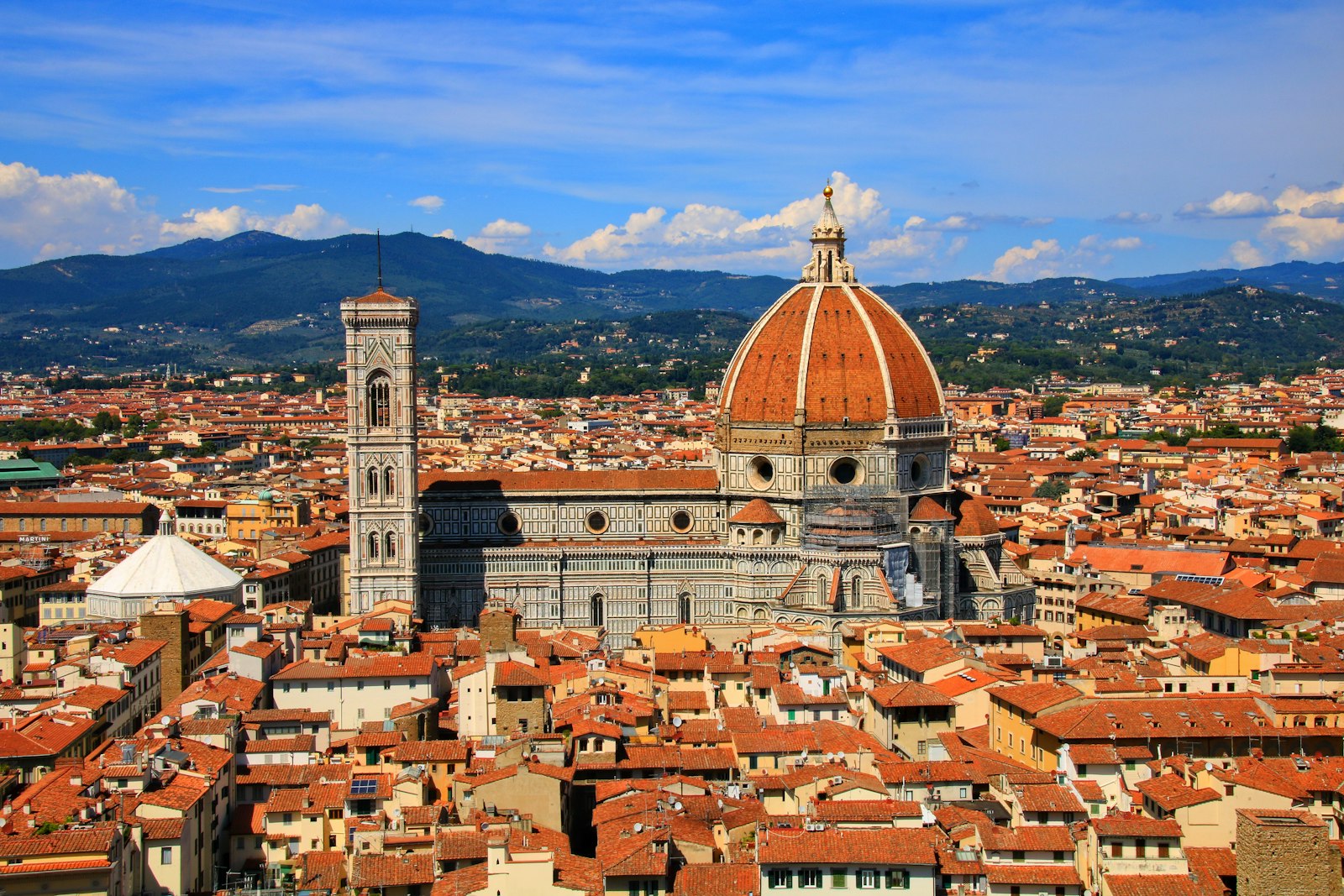 Florence's terracotta rooftops and the red dome of the Duomo seen from above. Photo by Andrea Woods on Unsplash.