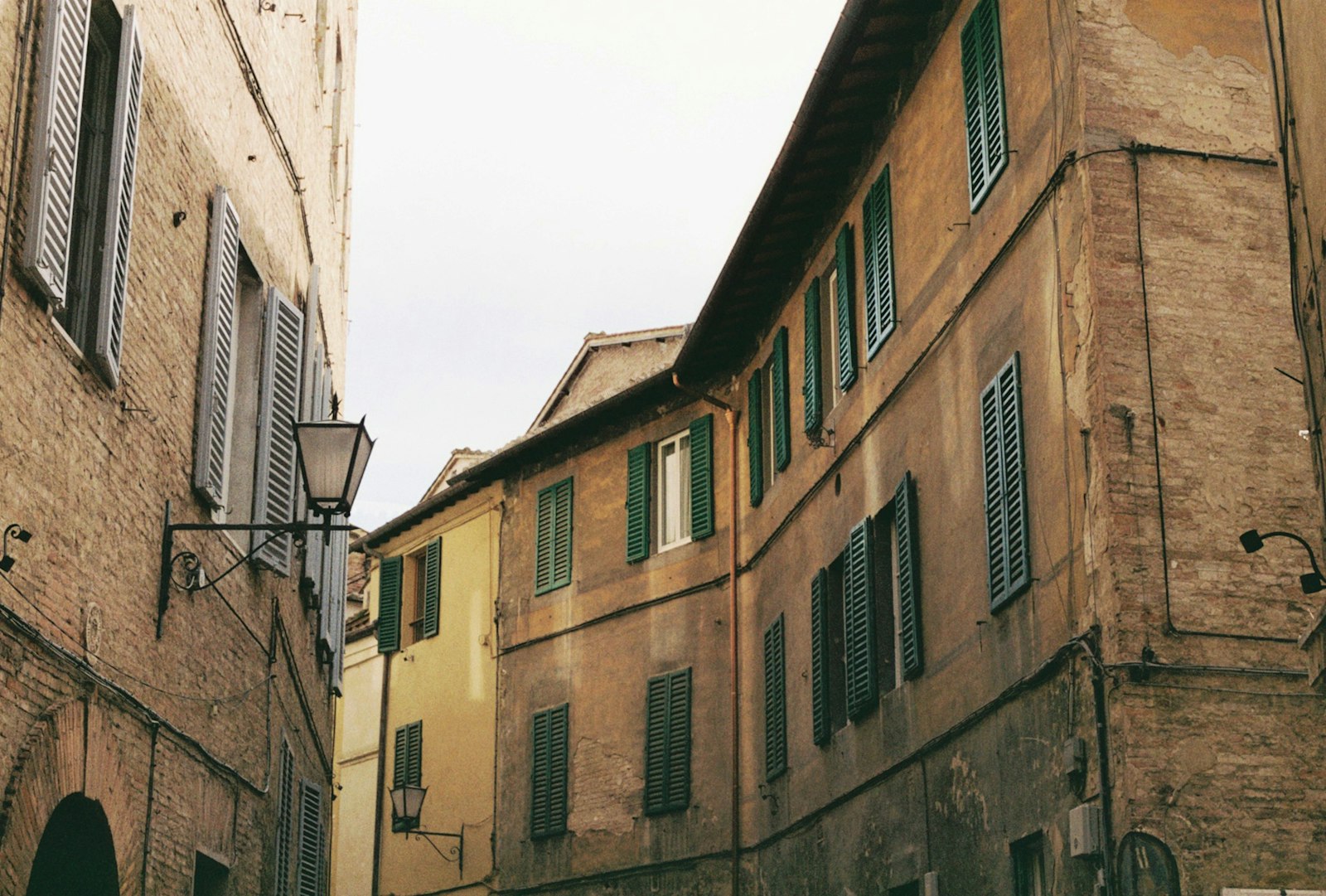 A narrow medieval brick street climbing through the old town of Siena. Photo by Denis on Unsplash.