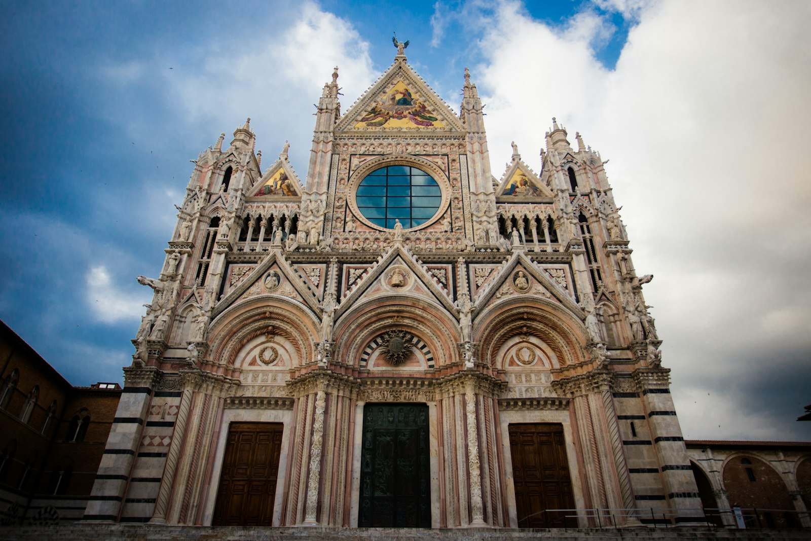 The ornate black-and-white striped marble facade of Siena's Duomo. Photo by Il Vagabiondo on Unsplash.