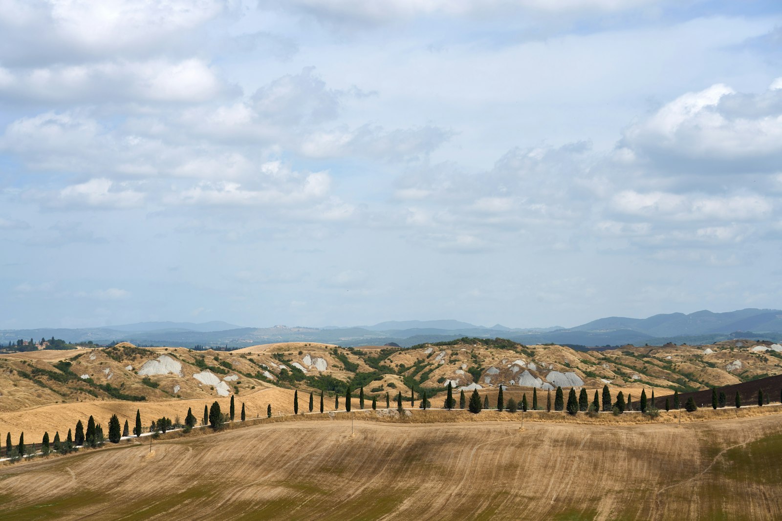 The bare, rolling clay hills of the Crete Senesi south of Siena. Photo by Wolfgang Hasselmann on Unsplash.
