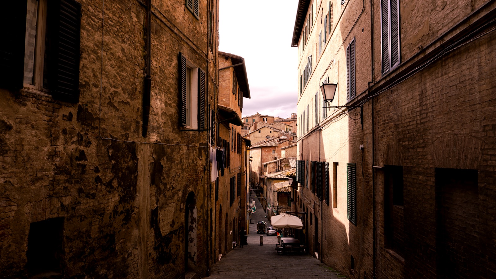 A narrow medieval stone street in Siena's old town, the heart of a contrada. Photo by Fabrizzio Moncada on Unsplash.
