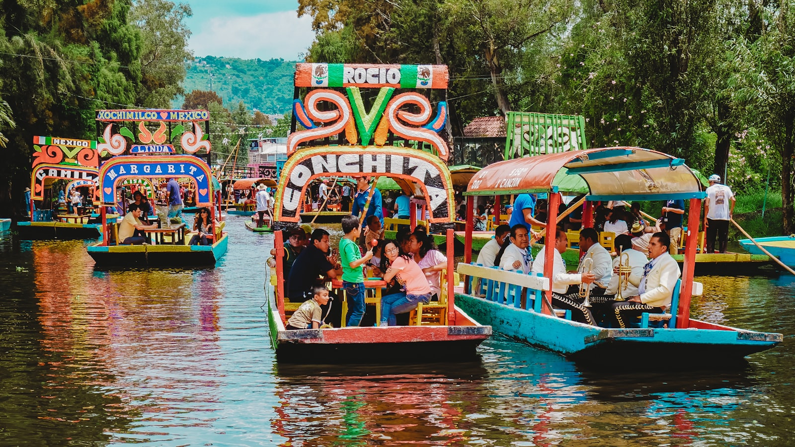 Colorful trajineras full of groups on the canals of Xochimilco, Mexico City. Photo by Roberto Carlos Román Don on Unsplash.