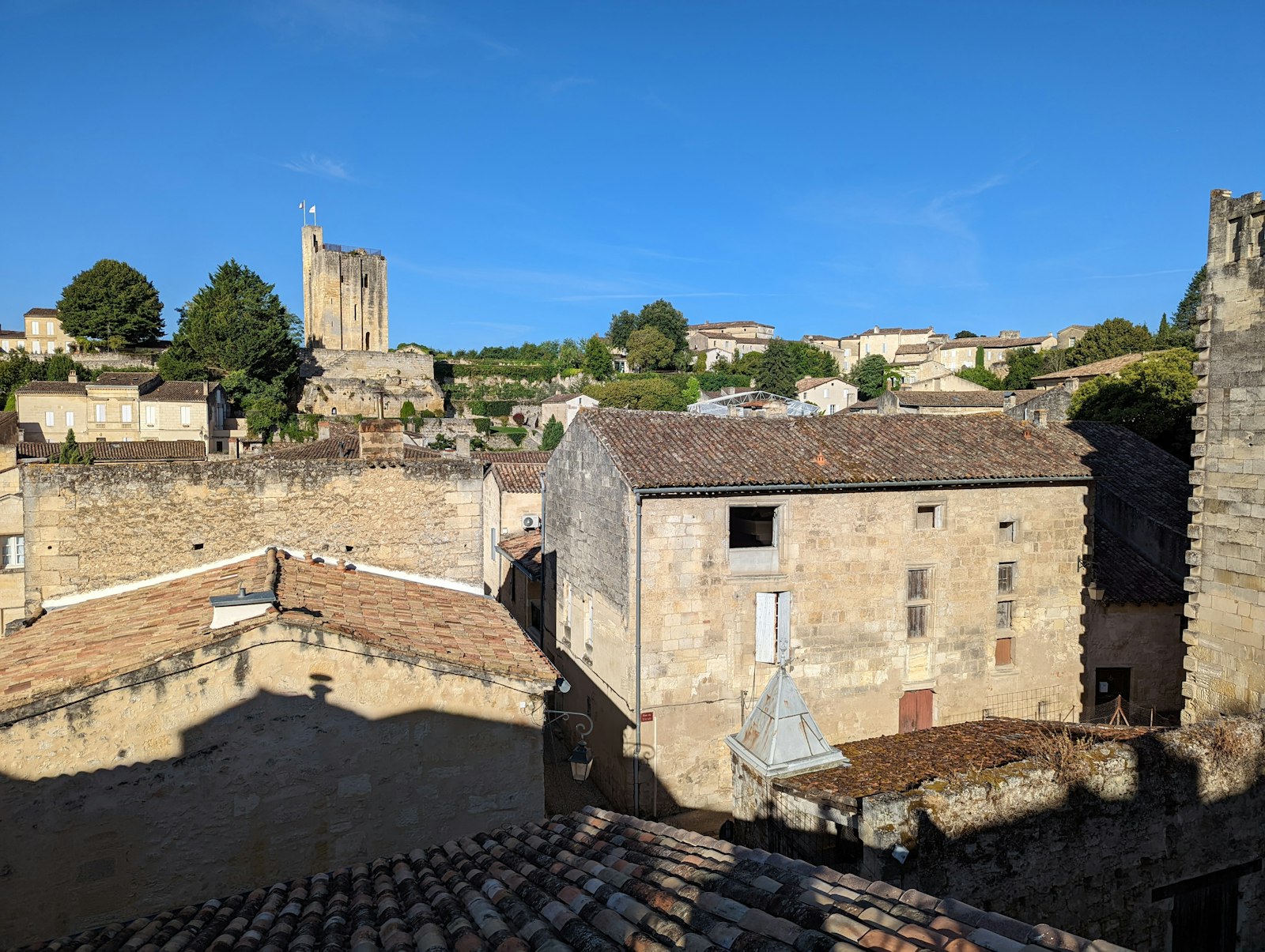 The golden rooftops and bell tower of Saint-Émilion above the vines. Photo by Simon James on Unsplash.