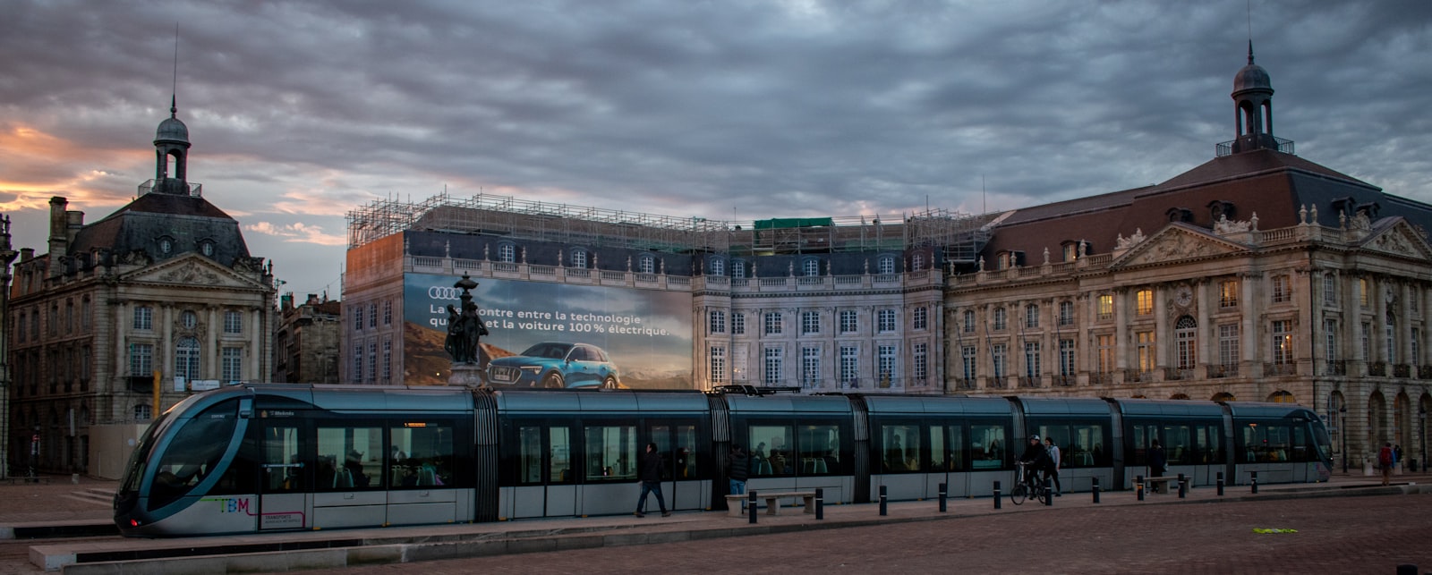 Un tranvía de Burdeos pasando frente al Palais de la Bourse junto al río. Foto de Clovis Wood en Unsplash.