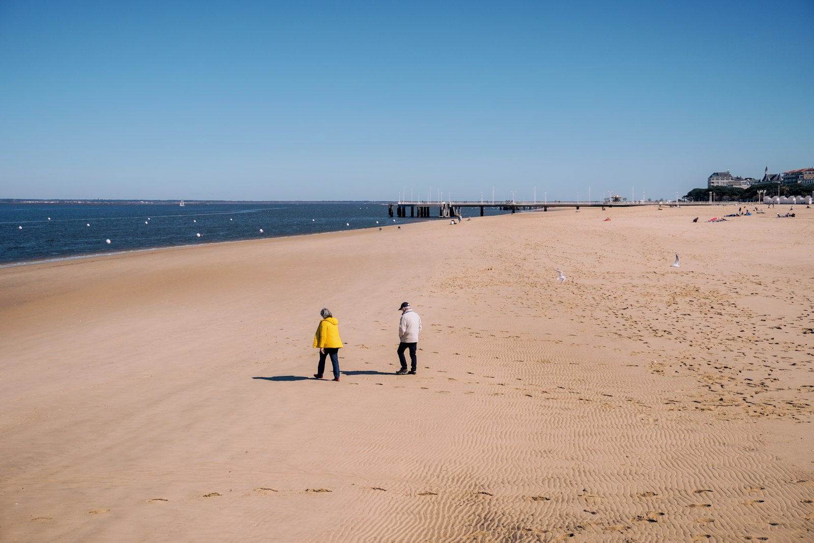 Two tiny figures crossing the vast sand of the Dune du Pilat near Arcachon. Photo by Kseniia Poroshkova on Unsplash.
