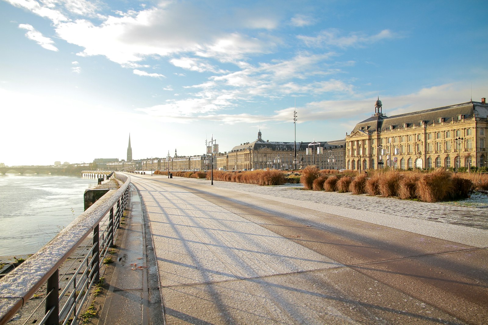 The long curving stone quay along the Garonne in Bordeaux, the Place de la Bourse in the distance. Photo by Vince Gx on Unsplash.