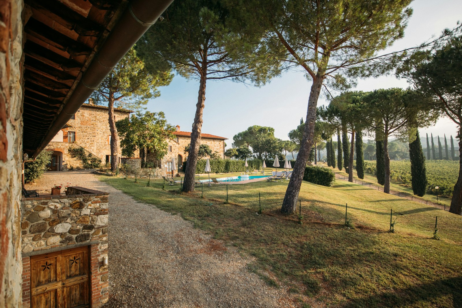 A stone Tuscan villa with a garden, umbrella pines, and a pool in the hills. Photo by Rafael Peier on Unsplash.