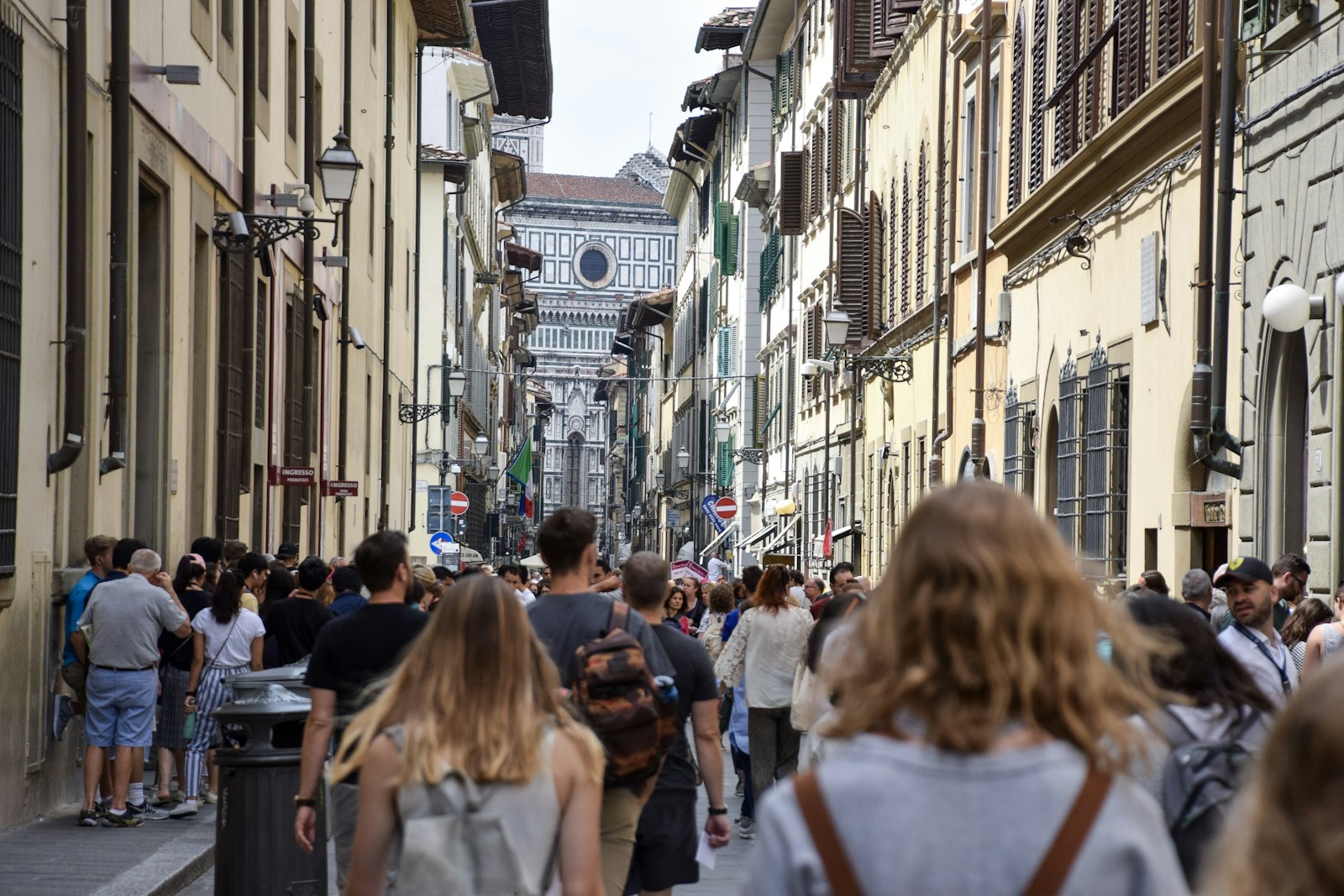 A crowd walking a narrow Florence street toward the Duomo. Photo by Taylor Smith on Unsplash.