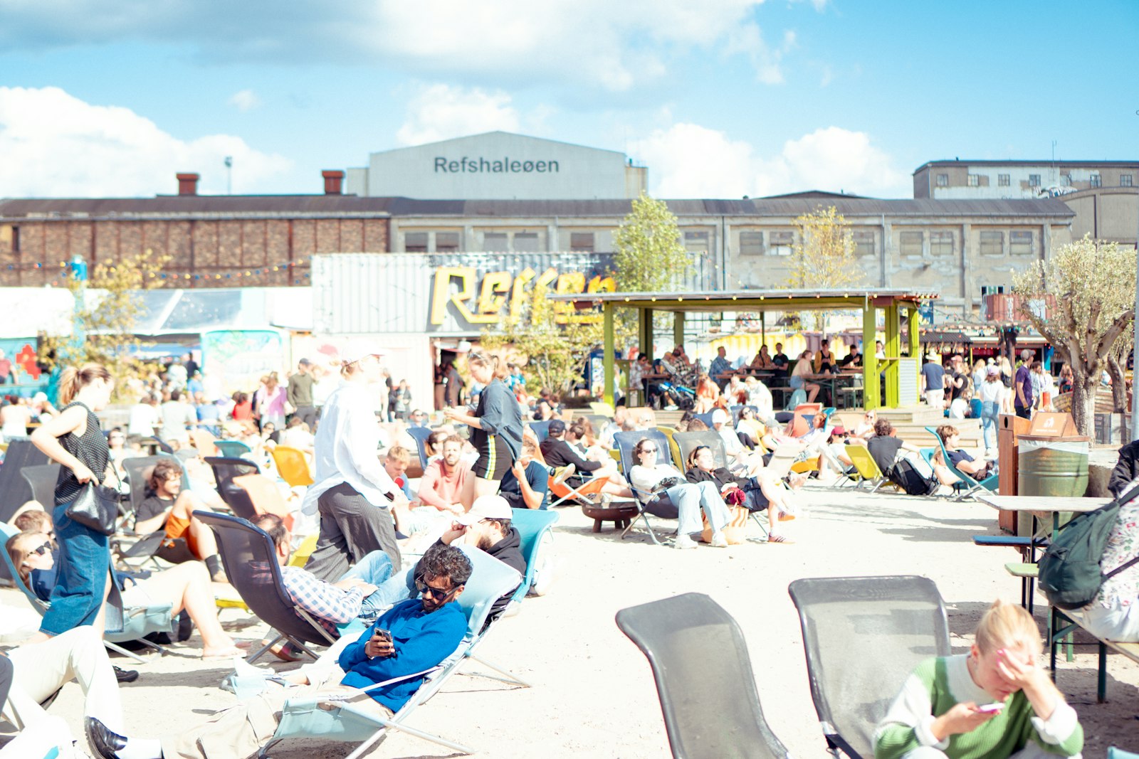 A sunny crowd gathering to eat outdoors at the Reffen street-food market on Refshaleøen, Copenhagen. Photo by Patrick Federi on Unsplash.